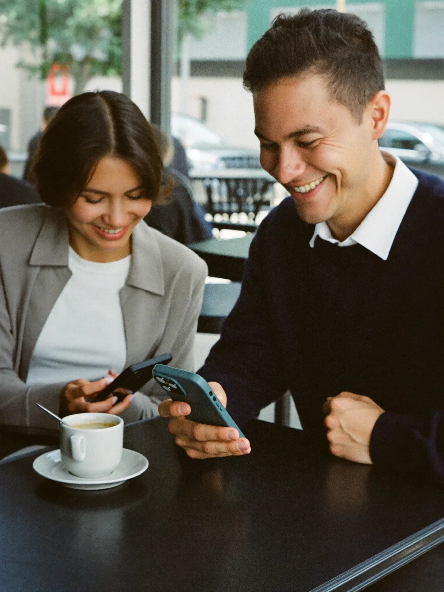 AI-genereret: To veninder på en café, den ene viser den anden noget på mobilen.