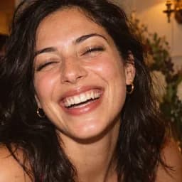 AI-generated: Portrait of a laughing woman with dark curls.
