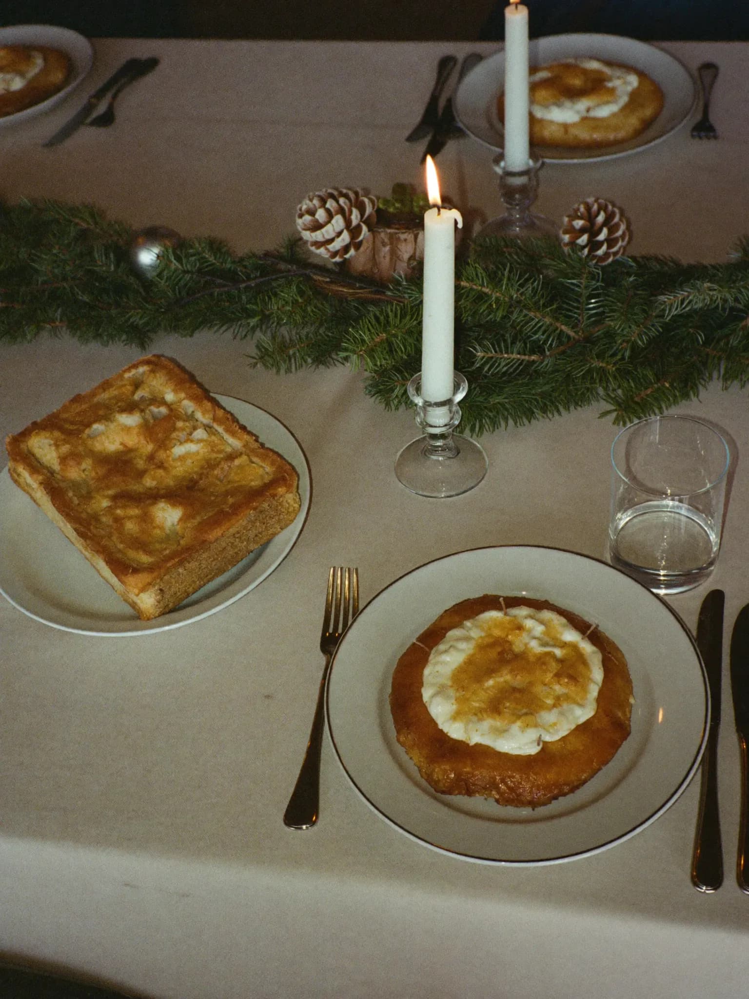 AI-genereret: Dækket julebord med lys og grangrene.
